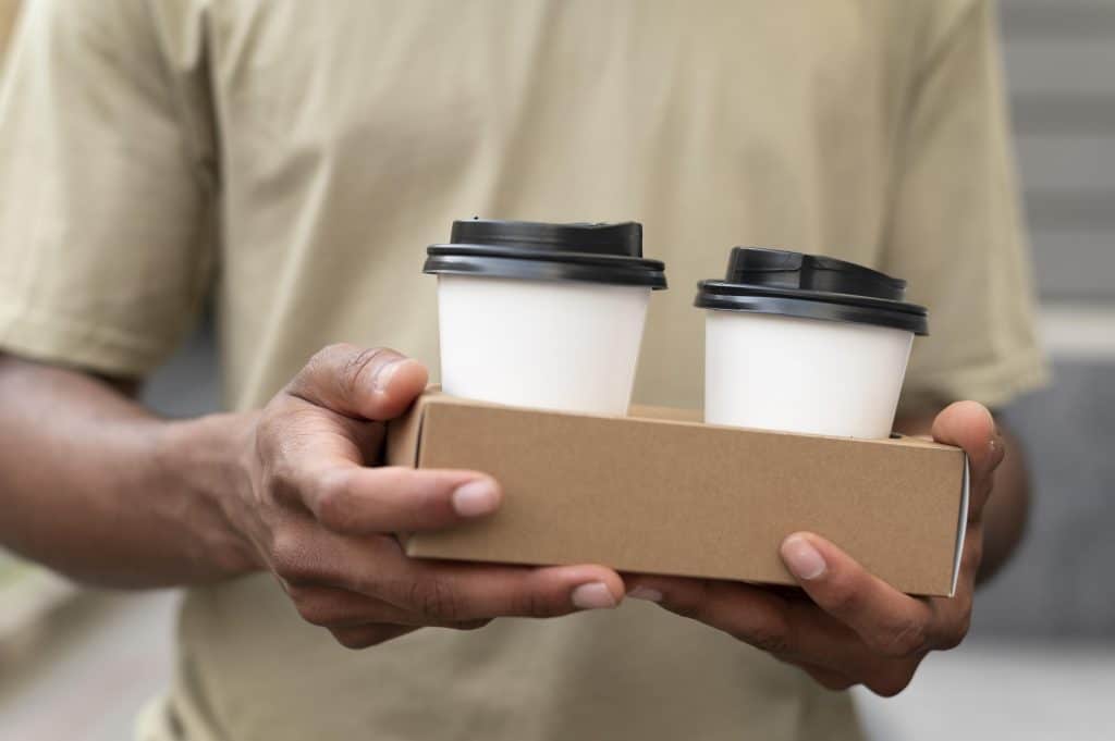 young man holding takeaway coffee